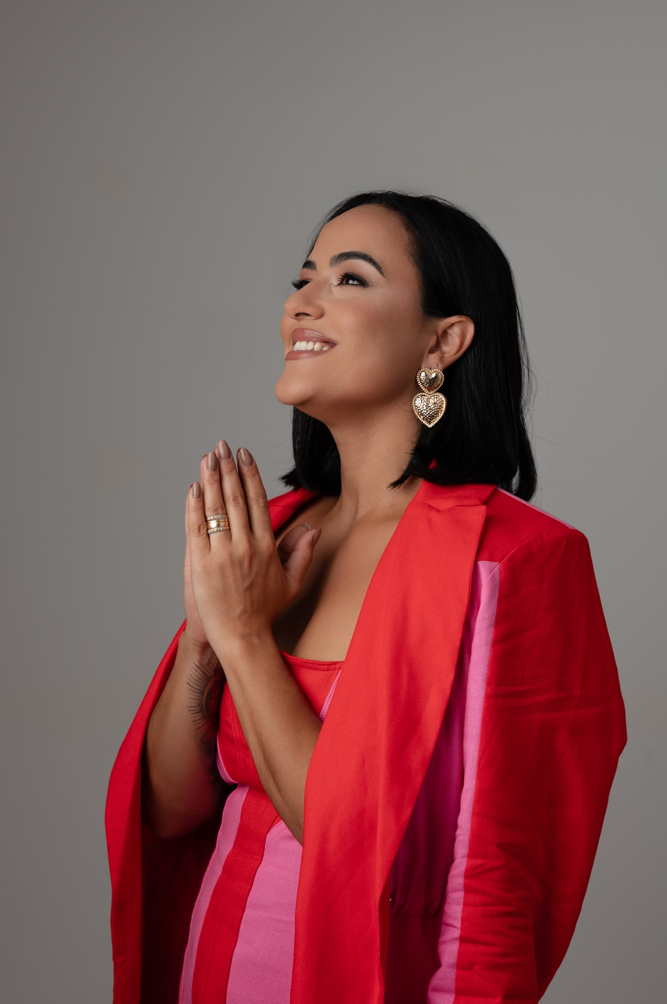 Camila Meneses de olhos fechados, com as mãos unidas em oração