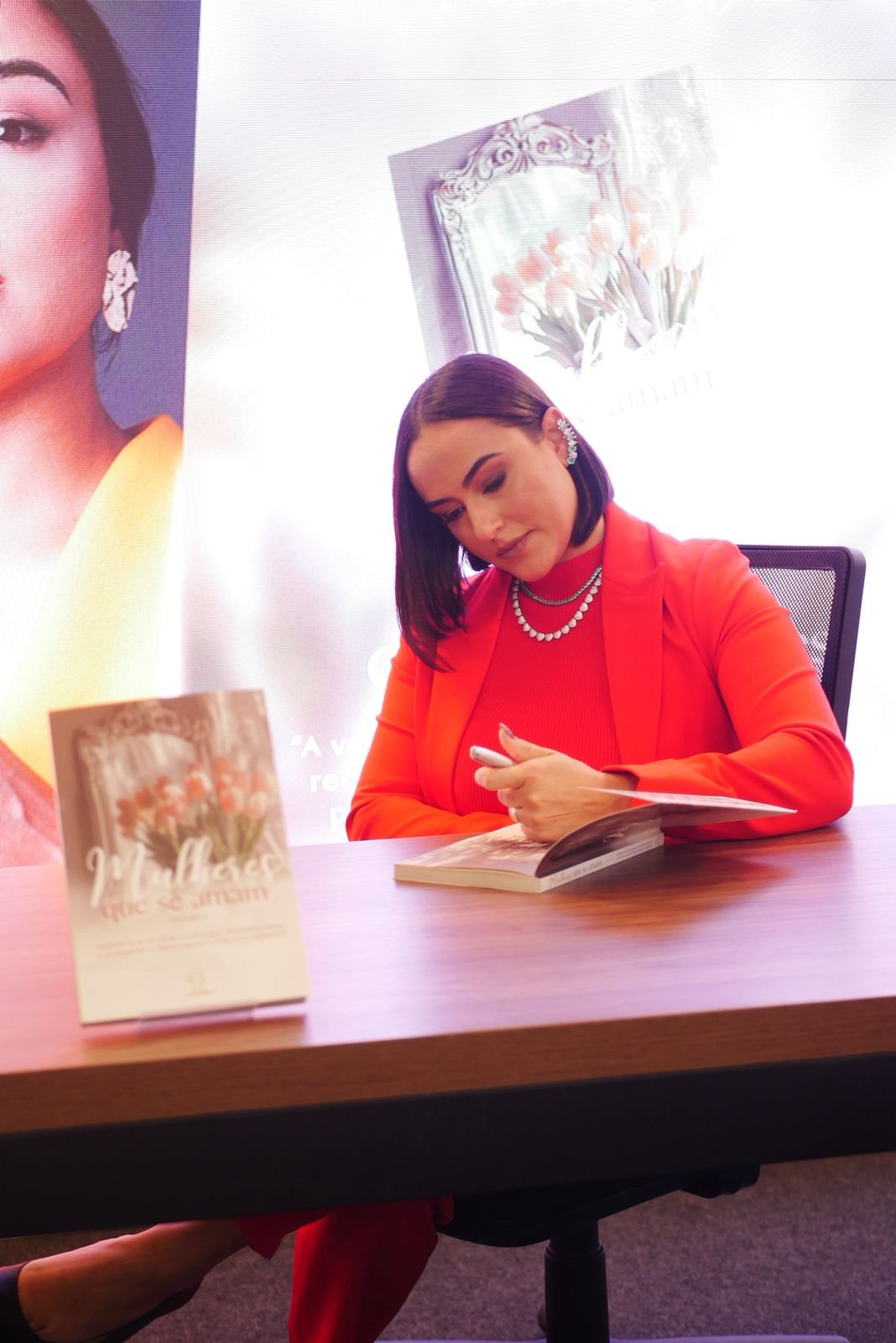 Camila autografando exemplares no lançamento do livro